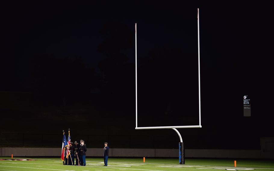 Joseline Leyva, right, watches the newest color guard cadets present the flags before the football game. 