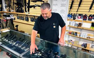 John Parkin, co-owner of Coyote Point Armory displays a handgun at his store in Burlingame, Calif., June 23, 2022.
