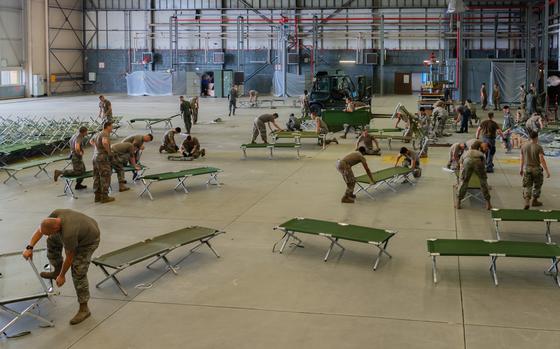 Airmen set up cots at a hangar on Ramstein Air Base, Germany, Aug. 19, 2021. Ramstein Air Base is providing lodging for evacuees from Afghanistan as part of Operation Allies Refuge during the next several weeks. 
