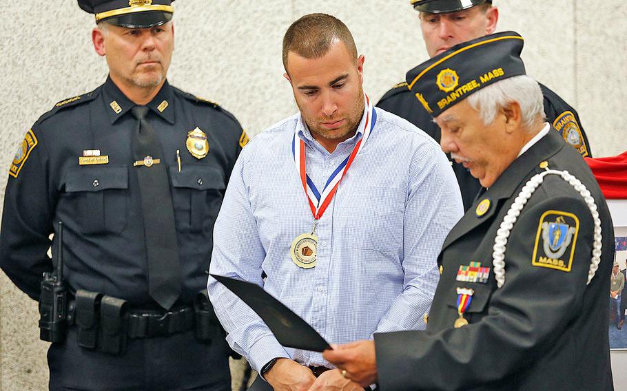 Braintree police officer Matthew Donoghue receives a World War II Peace Medal at the Braintree police station on Nov.11, 2021.