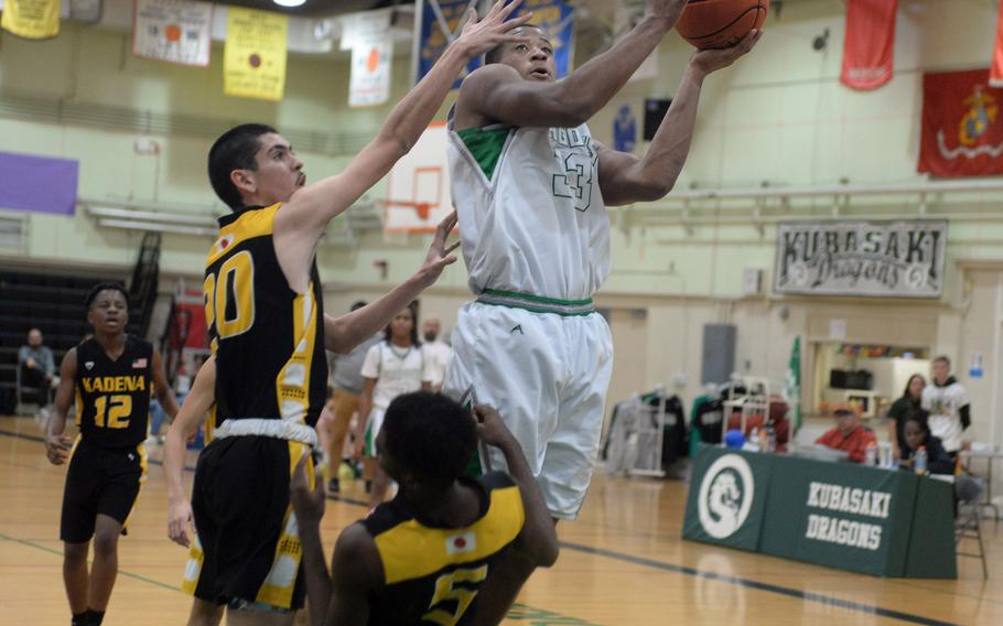 Kubasaki's T.J. Reese plows into Kadena's Cedric Dorelein while driving to the basket during Thursday's Okinawa boys basketball game. Reese was called for an offensive foul and fouled out of the game. The Panthers won 42-39.