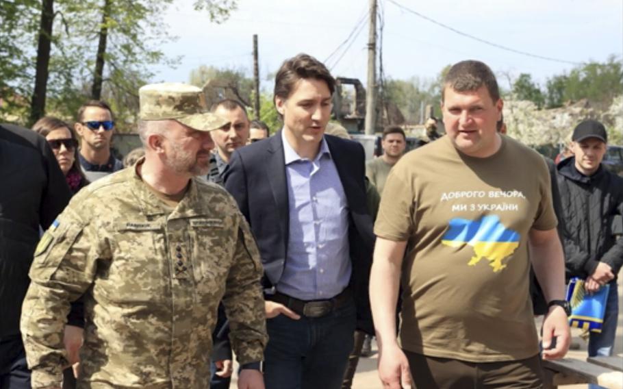 This image provided by the Irpin Mayor’s Office shows Canadian Prime Minister Justin Trudeau walking with mayor Oleksandr Markushyn, right, in Irpin, Ukraine, Sunday, May 8, 2022. Trudeau made a surprise visit to Irpin on Sunday. The city was severely damaged during Russia’s attempt to take Kyiv at the start of the war.