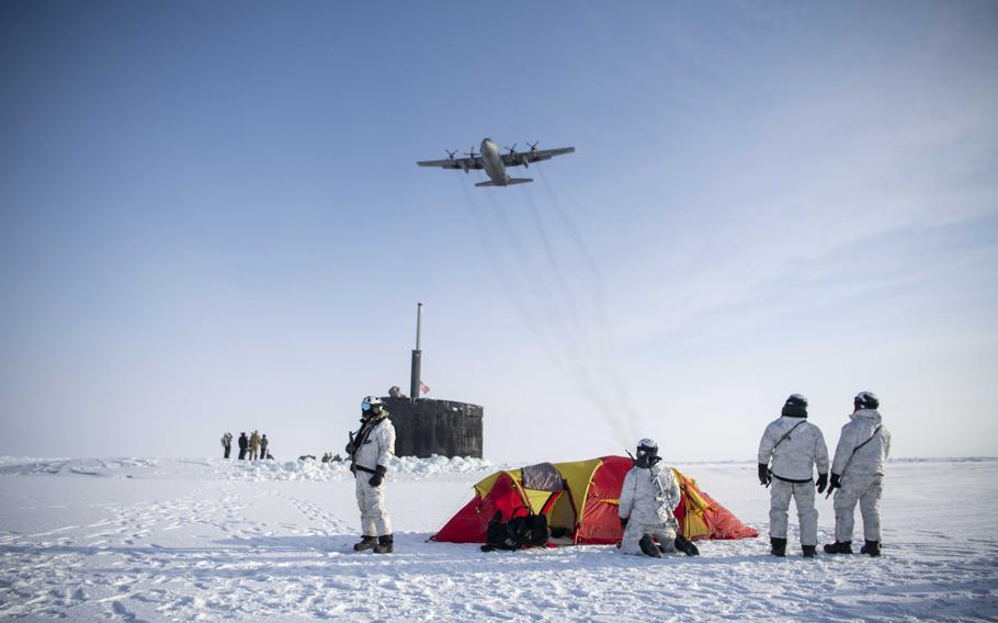 A C-130 Hercules assigned to the 109th Airlift Wing, part of the New York Air National Guard, flies over Navy SEALs, Norwegian naval special operations commandos and the attack submarine USS Hampton during an integration exercise in the Arctic Ocean, Saturday, March 9, 2024. 