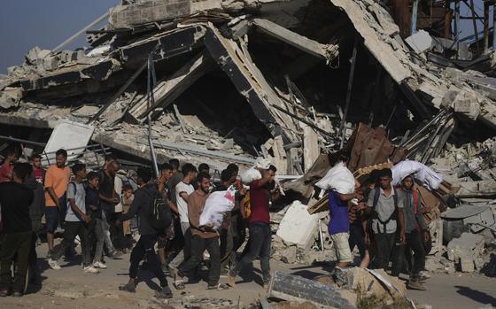 Palestinians carry humanitarian aid packages distributed by the Gaza Humanitarian Foundation operated by the U.S.-backed organization in Khan Younis, southern Gaza Strip, Thursday, June 26, 2025. (AP Photo/Abdel Kareem Hana)
