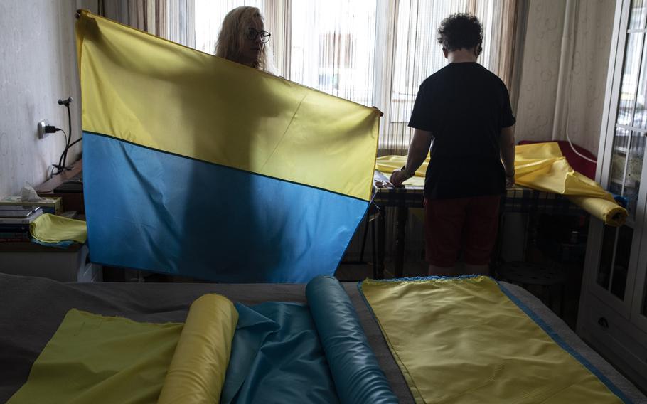 Iryna Arziaieva, 42, makes large Ukraine flags with the help of her son Illia, 15, in her home in Vyshneve, a Kyiv suburb on July 26, 2022. 