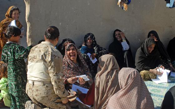 Marjah, Afghanistan, Jan. 23, 2011: Interpreter Ira Quraishi, a member of one of the Marjah-area Female Engagement Teams (FETs), gets a laugh from a local woman who attended a Marine-sponsored meeting with a local midwife to inform the women about hygiene, pregnancy and child care issues. 

Read Nancy Montgomery's reporting on the U.S. interpreters working with the FETs and the tough positions they sometimes found themselves in here.
https://www.stripes.com/news/american-interpreter-takes-a-stand-in-afghanistan-1.133124

META TAGS: Women's History Month; women in the military; Women combat reporters; 