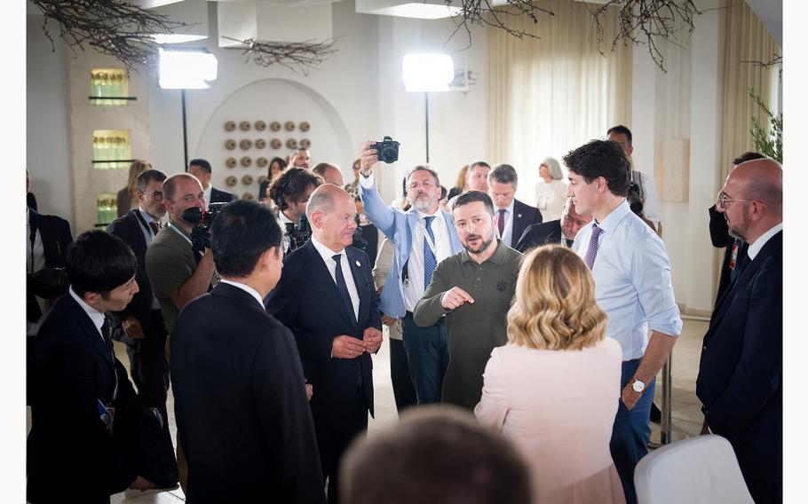 German Chancellor Olaf Scholz listens to Ukrainian President Volodymyr Zelenskyy during a working session at the G7 summit in Fasano, Italy, June 13, 2024. 