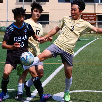 Humphreys’ Matthew Hwang plays the ball in front of Osan’s Chris Baia during Saturday’s DODEA-Korea soccer match. The Blackhawks won 6-3.