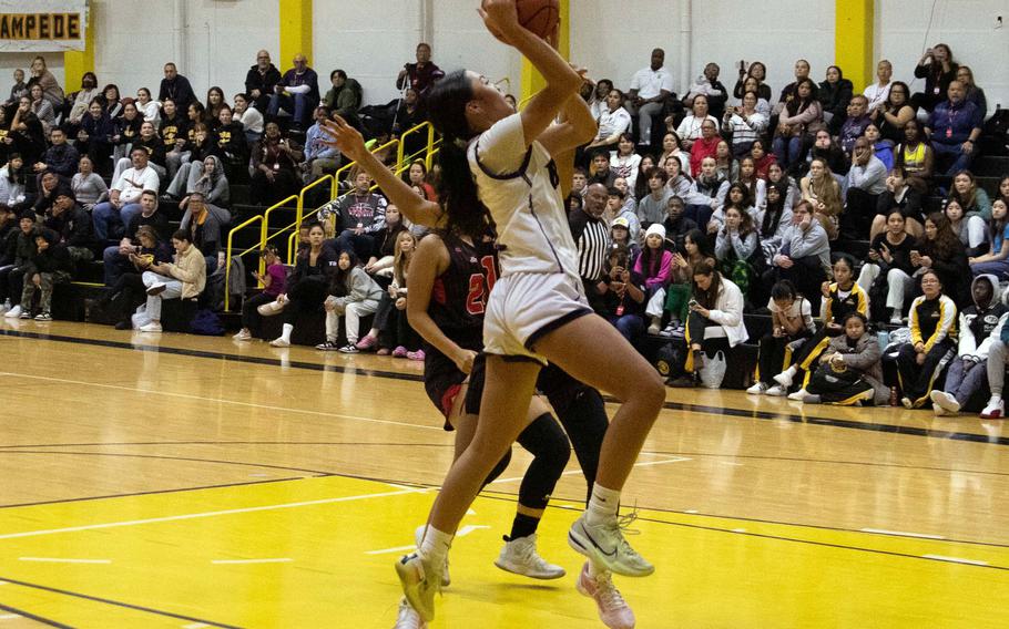 Academy of Our Lady's Maddie Ada drives to the basket against Nile C. Kinnick. The Cougars won the ASIJ Kanto Classic girls final 27-19.