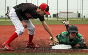 Kubasaki's Camden Fisk slides in safe at third base ahead of the tag by Kinnick's Aaden Otteson.
