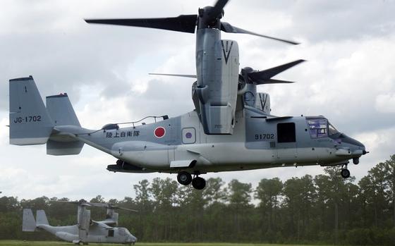 An Osprey tiltwing aircraft flies close to the ground.