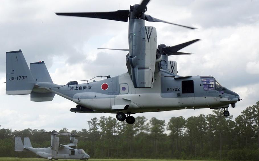 An Osprey tiltwing aircraft flies close to the ground.