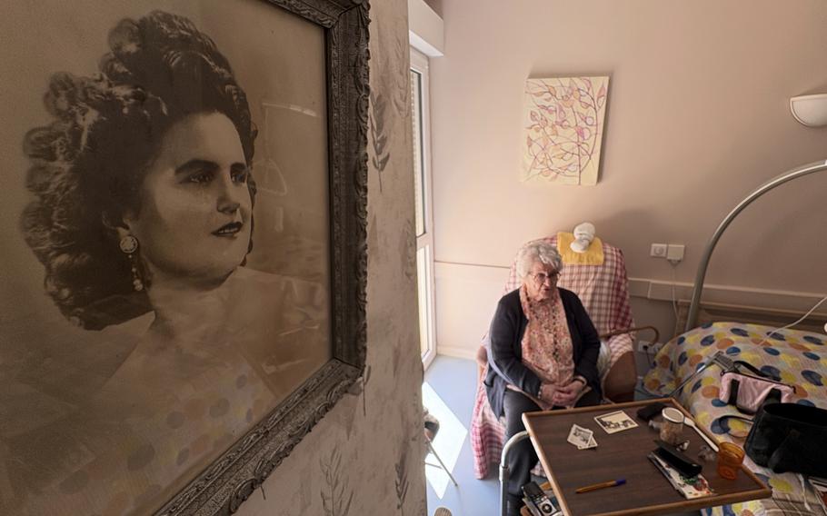 Genevieve Perrier, 99, a civilian under Nazi occupation, answers the Associated Press, with a portrait of her when she was 20 in 1945, on Tuesday April 29 2025 in Precy sous Thil, Burgundy, France. 