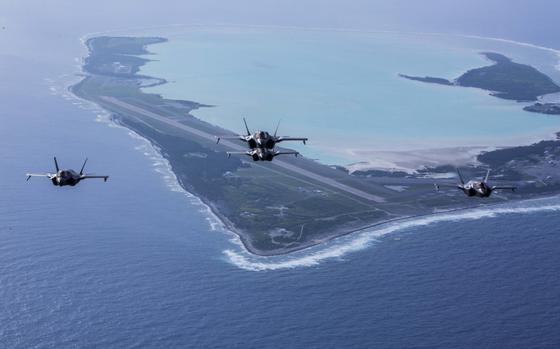Aircraft fly high above Wake Island Airfield, which stretches out in the sea below.