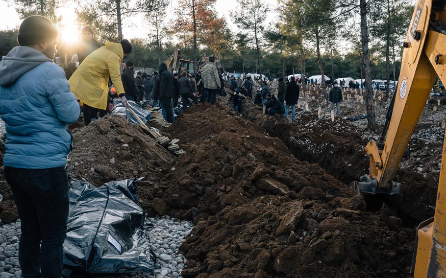 People gather for burial of earthquake victims at a makeshift cemetery on the outskirts of Kahramanmaras, Turkey, on Thursday.