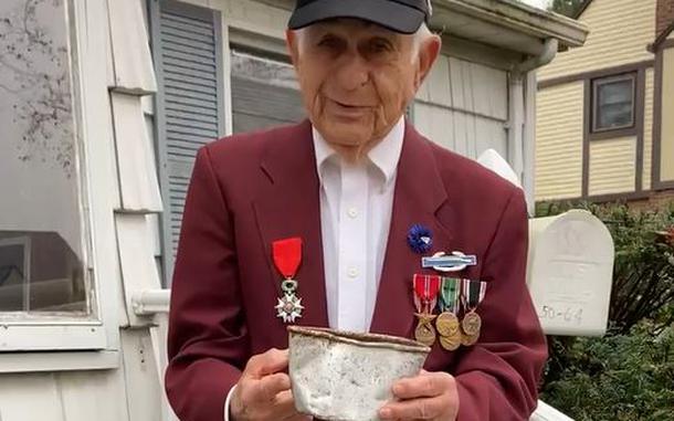 Harold Radish shows off a mess kit cup that was returned to him after losing it during World War II.