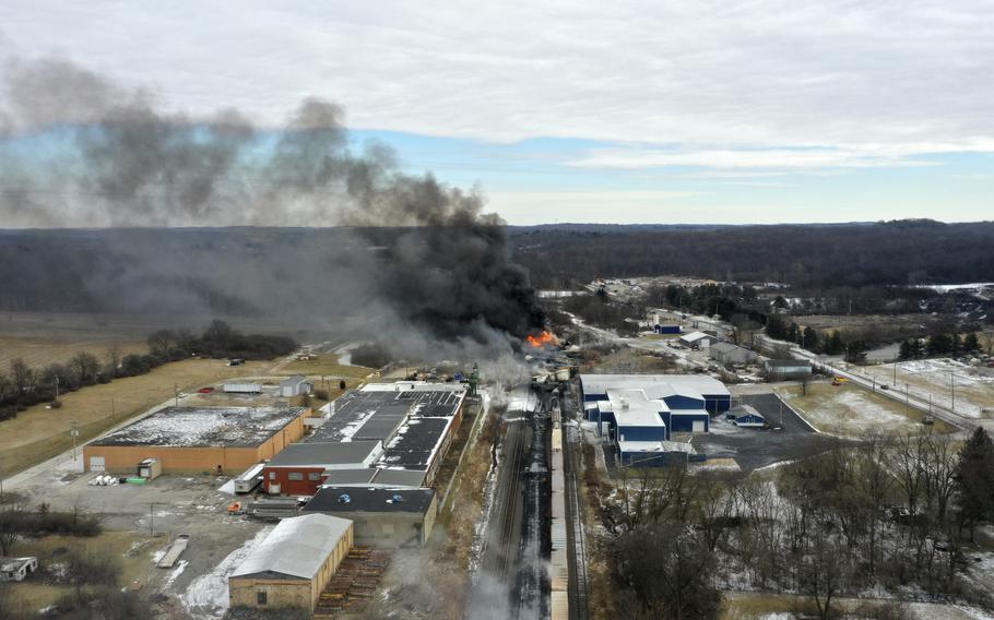 Smoke and flames rise from the site of a train derailment.