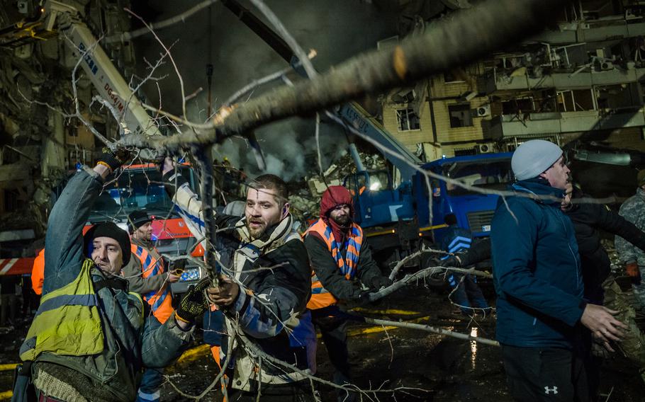 Rescuers and civilians work to free victims from the rubble of a residential apartment complex that was hit by Russian forces in Dnipro, Ukraine, on Jan. 14, 2023.