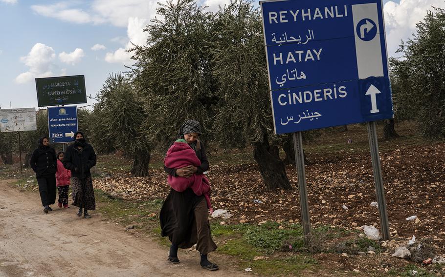 Locals walk miles away from their town in Jinderis, Syria, on Friday, Feb. 10, 2023, after their homes were destroyed by major earthquakes.
