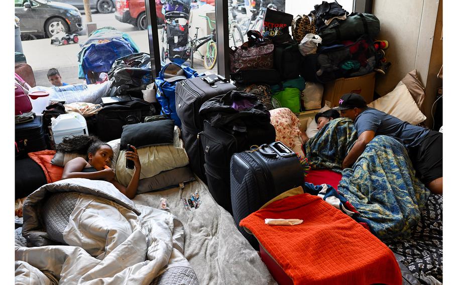 Migrants lie in their makeshift shelter at the Chicago Police Department's 15th District station. 