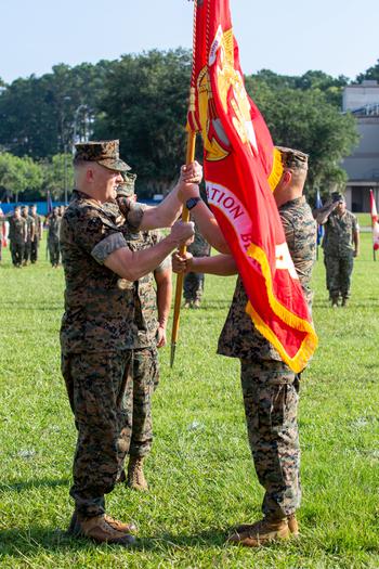 U.S. Marine Corps Col. Karl Arbogast, outgoing commanding officer, Marine Corps Air Station (MCAS) Beaufort, passes the colors to Col. Mark Bortnem, incoming commanding officer, MCAS Beaufort, during a Change of Command Ceremony at MCAS Beaufort, S.C., July 7, 2023. 