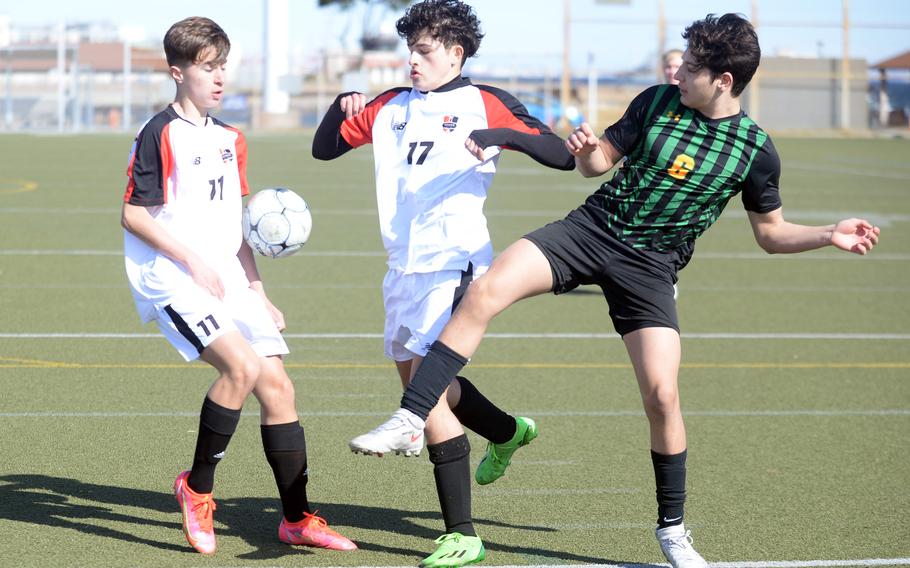 Nile C. Kinnick's Kurtis Mole and Esteban Diaz and Robert D. Edgren's Sebastian Sanchez try to settle the ball during Saturday's DODEA-Japan boys soccer match. The Red Devils shut out the Eagles 7-0.