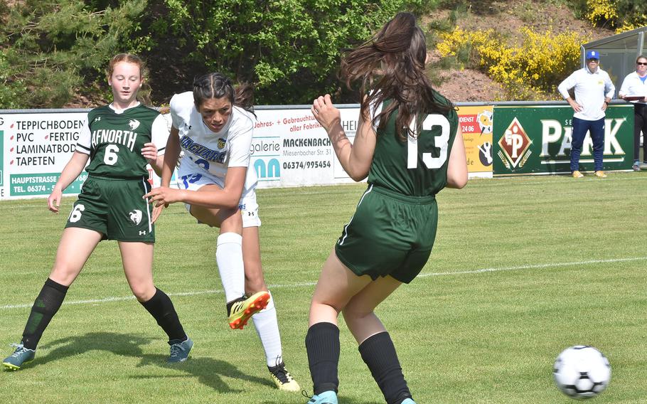 Sigonella’s Ryleigh Denton takes a shot on goal Monday, May 16, 2022, while guarded by AFNORTH’s Sara Nix, left, and Paula Bohlen in the DODEA-Europe girls Division III soccer championships in Reichenbach, Germany.