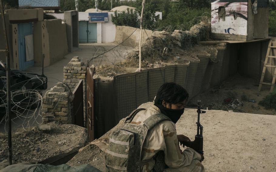 A police officer sits in an outpost in Kandahar, Afghanistan, as Afghan security forces find themselves engaged in a battle with the Taliban inside the city limits. 