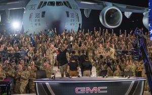 In this handout photo from the U.S. Air Force, American service members participate in a live broadcast with the hosts of Fox NFL Sunday during their Salute to Veterans broadcast, Nov. 13, 2022 at Al-Udeid Air Base in Qatar. As over a million World Cup fans fill stadiums with cheers and carry heady optimism through the streets of Doha, some 8,000 American troops are running air wars in Afghanistan, Iraq, Syria and other hotspots in the Middle East mere miles away. (U.S. Air Force/Airman 1st Class Andrew Britten, via AP)