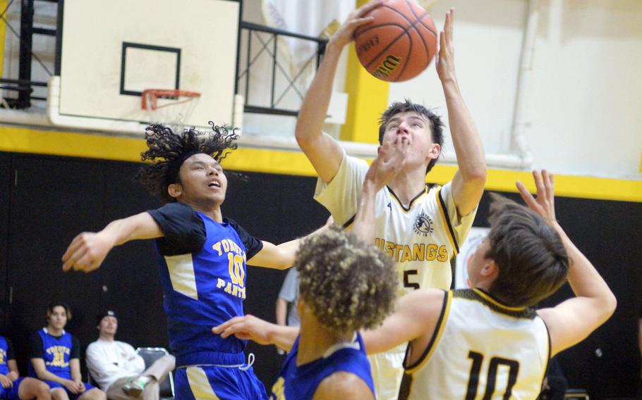 American School In Japan's Ayden Carreon skies for a rebound against Yokota. The Mustangs won 51-32.