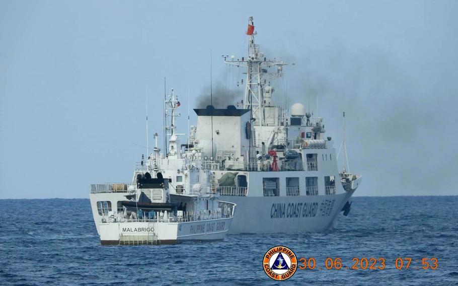 A Chinese coast guard ship blocks a Philippine coast guard vessel in the South China Sea, June 30, 2023.