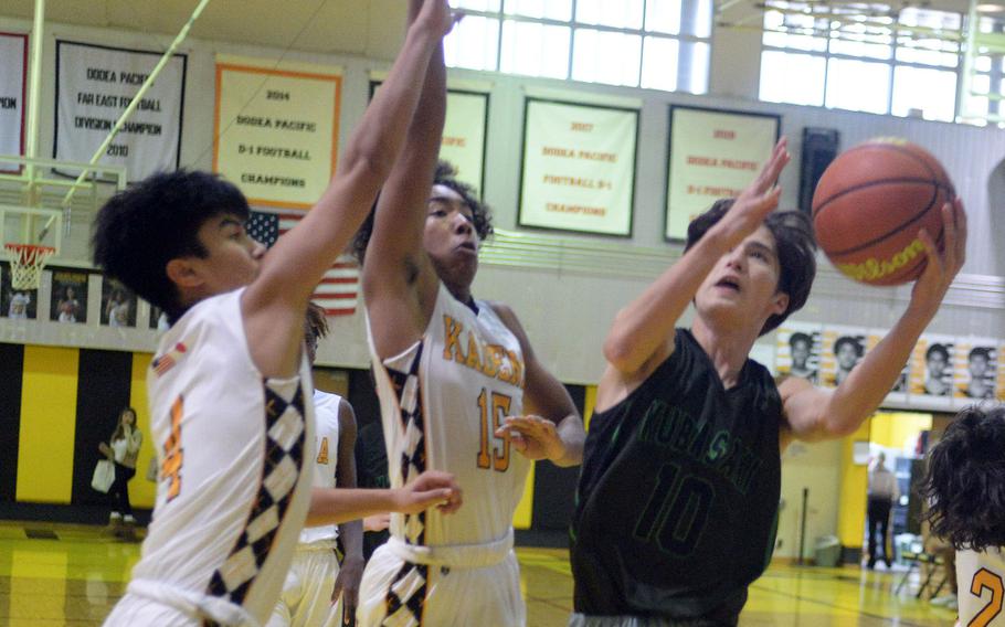 Kubasaki's Troy Harris shoots against Kadena's Cory Tripp and Jaden Patsel during Friday's DODEA-Okinawa boys basketball game. The Panthers won 58-29, improving to 3-0 against the Dragons this season.