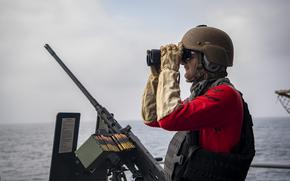 A U.S. sailor searches for a target Aug. 2, 2025, during an exercise on the fantail of the aircraft carrier USS Nimitz in the U.S. Central Command area of responsibility. Nimitz has since pulled into Bahrain for a port call.