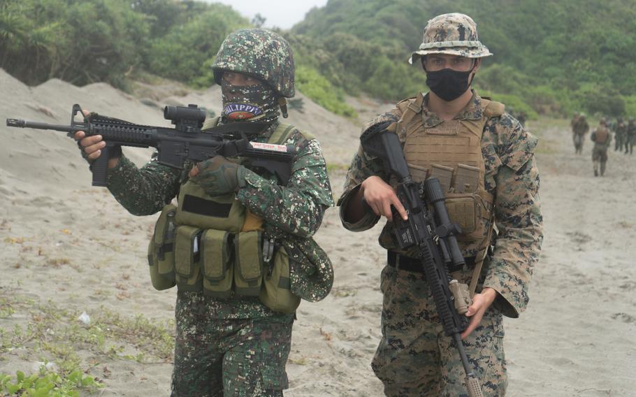 A Filipino soldier patrols alongside a U.S. Marine during the Balikatan exercise in Claveria, Cagayan, Phillippines, April 2, 2022. 