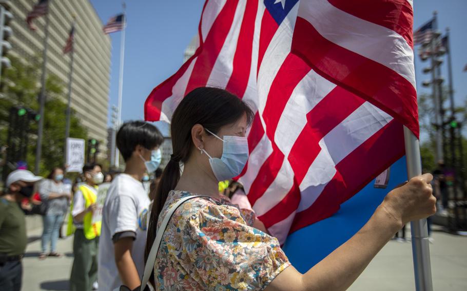Jan Liu holds an American flag in Grand Park as she is participates in a Youth Against Hate rally in light of anti-Asian violence and hate crimes on Saturday, May 8, 2021, in Los Angeles.