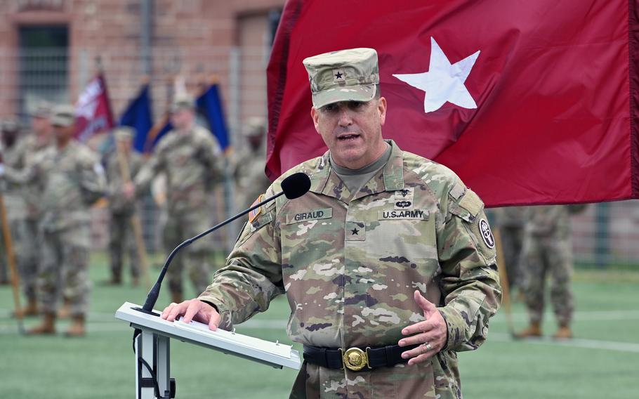 A man in an Army uniform gestures with one hand while speaking at a podium.