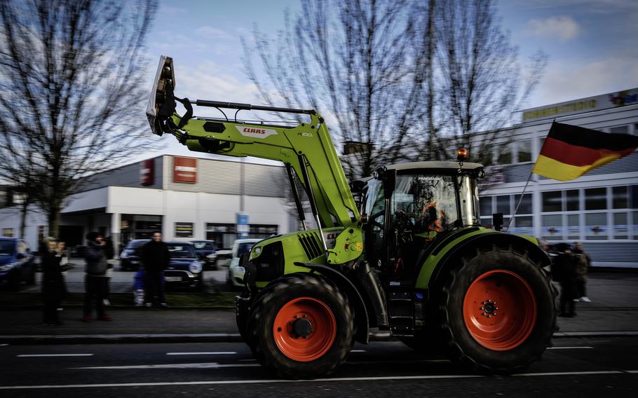 Farmers aboard their tractors roll down a main road in Kaiserslautern, Germany, on Jan. 8, 2024, highlighting their opposition against agricultural policy changes announced by the German government.