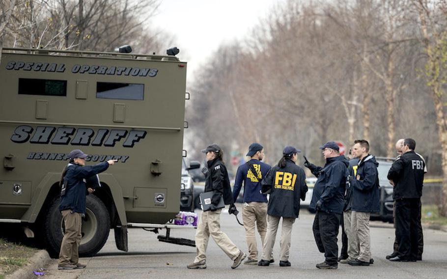 Law enforcement personnel join a SWAT unit from the FBI seen on April 27, 2023, in Minneapolis where they had been serving an arrest warrant.