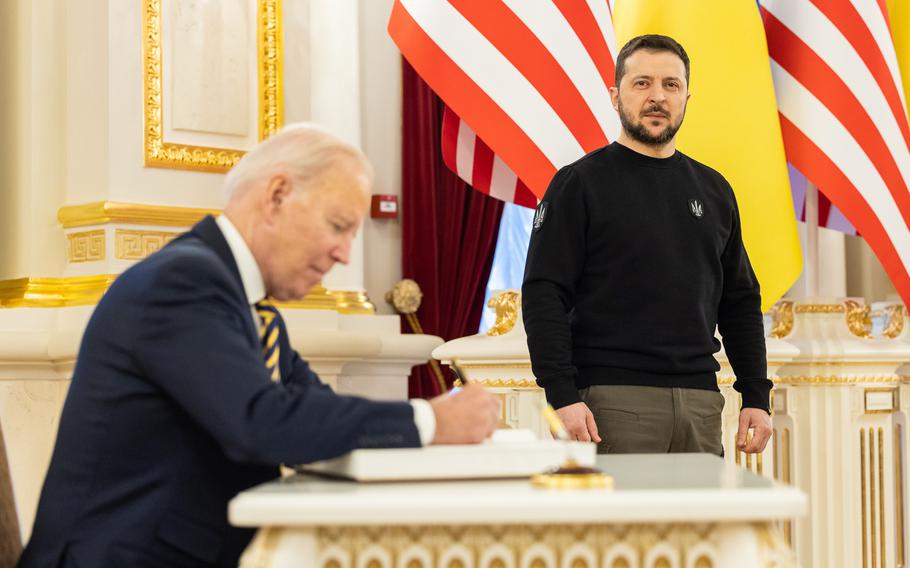 U.S. President Joe Biden signs the guest book during a meeting with Ukrainian President Volodymyr Zelensky at the Ukrainian presidential palace on Feb. 20, 2023, in Kyiv, Ukraine. The US President made his first visit to Kyiv since Russia's large-scale invasion last Feb. 24.