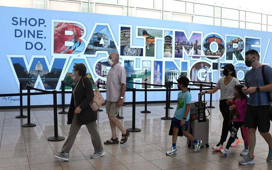 Passengers walk by a Baltimore Washington sign in the main terminal at Baltimore Washington International Thurgood Marshall Airport.
