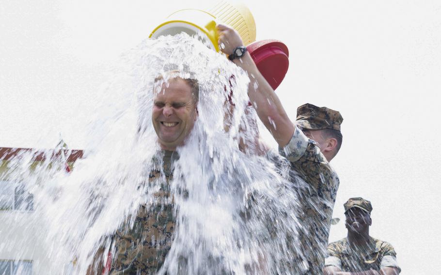 Marines dump water onto Col. Matthew Danner, commander of the 31st Marine Expeditionary Unit, during a fundraiser at Camp Hansen, Okinawa, April 28, 2023. 