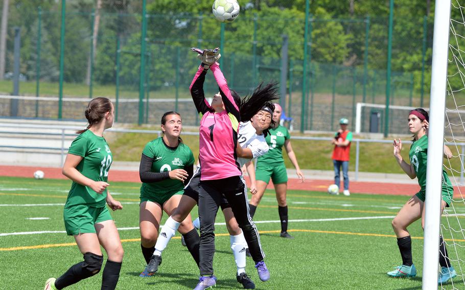 Naples keeper Anais Navidad punches the ball away in front of Vicenza’s Kiera Mukai as teammates watch, in the Division II girls final at the DODEA-Europe championships at Ramstein, Germany, May 18, 2023. Naples won 3-1.