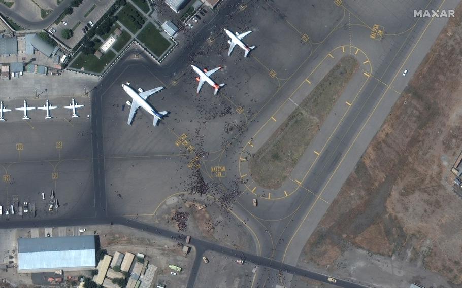 This satellite photo from Maxar Technologies shows swarms of people on the tarmac at Kabul International Airport on Monday Aug. 16, 2021. 