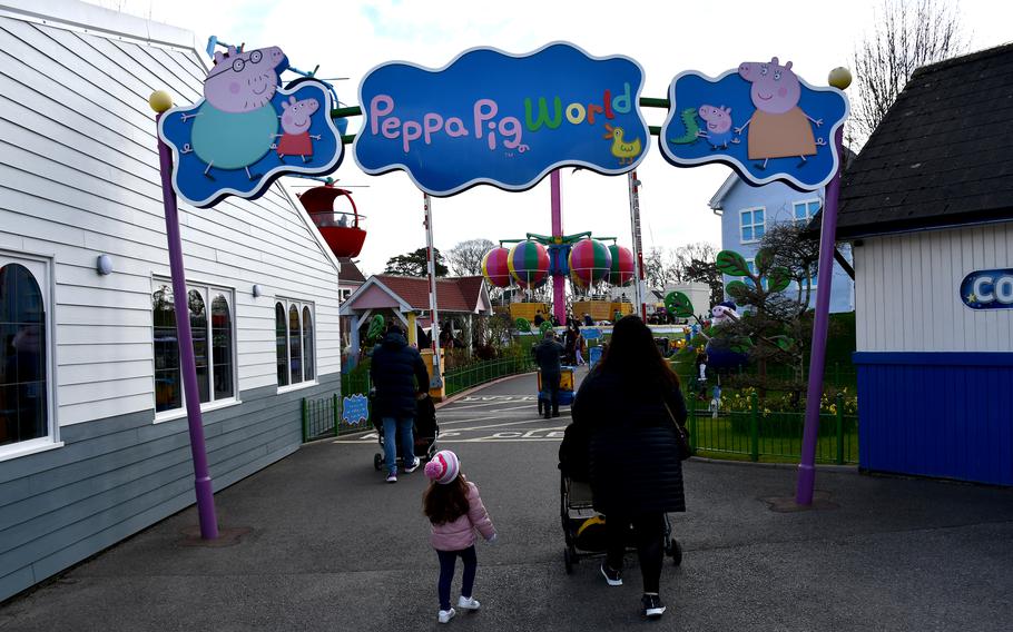 Visitors walk through the main entrance into Peppa Pig World in Romsey, England, April 2, 2022. Paultons Park hosts Peppa Pig World and four other theme parks. 