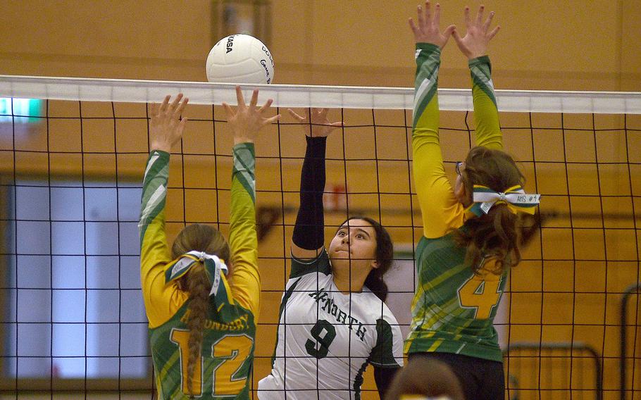 AFNORTH's Sophia Mier spikes at the net while Alconbury's Izzy Minjarez, left, and Brooke Barbee go for a block during pool-play action of the DODEA European volleyball championships on Oct. 26, 2023, at Kaiserslautern High School in Kaiserslautern, Germany.