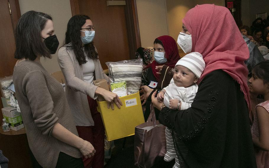 A gift box is given to Madina Mohammad, who is holding her 3-month-old son, Younus, at a baby shower for the Afghan women and their children living in the Philadelphia Residence Inn by Marriott, hosted by the Nationalities Service Center, in Philadelphia on Wednesday, Feb. 16, 2022. The event celebrated the women who recently had babies or were about to give birth. Many Afghan families are still living in the hotel while they await permanent housing. 