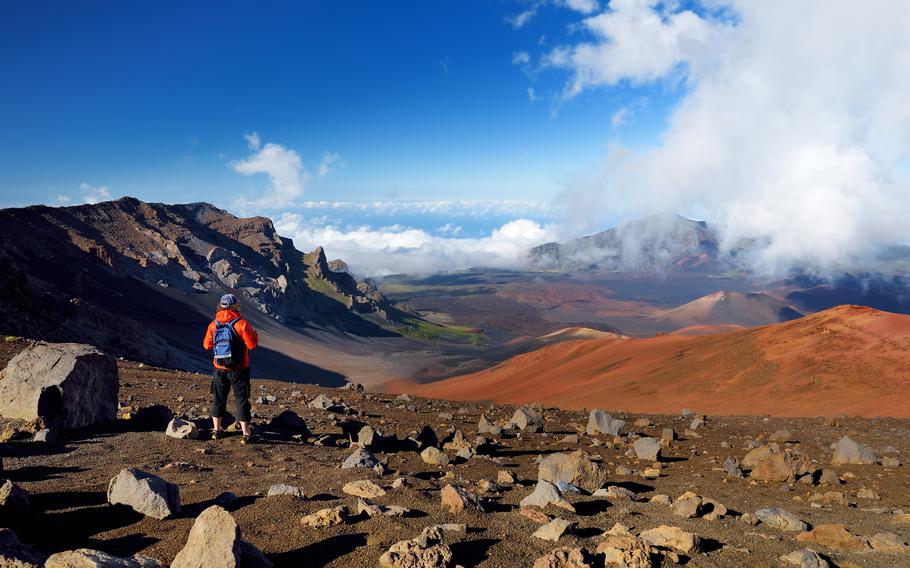 A hiker stands at the edge of the Haleakala crater. According to one of the many legends associated with the Polynesian demigod Maui, he captured the sun at the 10,000-foot summit of Haleakala. After receiving a promise from the sun to traverse the sky more slowly, so people would have more daylight, Maui released his captive. The mythology of a place greatly influences the everyday lives of locals. Understanding that mythology is akin to speaking the local language beyond the ability to order off a menu.