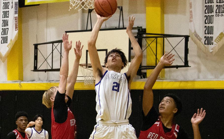 St. Mary's Julian Willis goes up to shoot between two Nile C. Kinnick defenders. The Titans won the ASIJ Kanto Classic final on a last-second bucket 40-38.