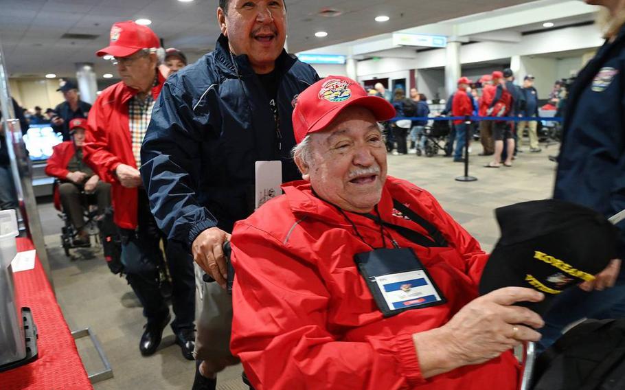 US Army veteran Sam Gonzales of Modesto, right, is escorted by David Baltierra, center, as the two and 62 others veterans prepare to board their flight for the Central Valley Honor Flight #21 Monday morning, May 16, 2022 at Fresno Yosemite International Airport.