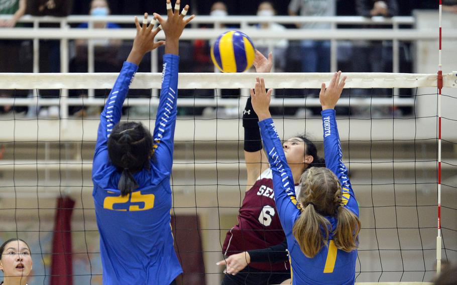 Seisen's Ann Katashiba spikes through the double block of Yokota's Trinity Stegall and Emma Hardy during Tuesday's Kanto Plain volleyball match. The host Phoenix won in three sets.